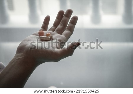 Smooth Focus In the woman's hand, there was an antidepressant pill in her hand because she had to regularly take antidepressant pills due to her paranoia and inability to control her feelings. Royalty-Free Stock Photo #2191559425