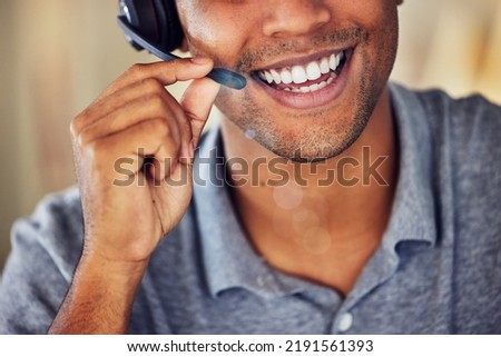 . Happy, smiling and friendly call center agent wearing headset while working in an office. Closeup smile of a confident man consulting and operating helpdesk for customer sales and service support. Royalty-Free Stock Photo #2191561393