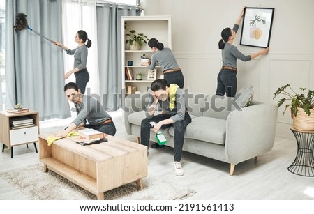 Woman multitasking, busy and cleaning the living room and doing all the chores. Tired superwoman, frustrated with time management and overworked on housework. Spring cleaning before family gets home Royalty-Free Stock Photo #2191561413