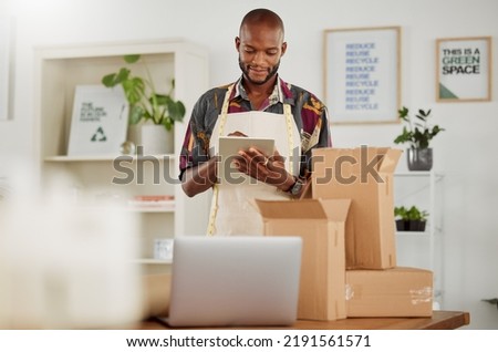 . Small business owner or creative startup entrepreneur checking an online order. Fashion, style and design with a trendy designer and tailor working on a tablet in his textile workshop or studio. Royalty-Free Stock Photo #2191561571