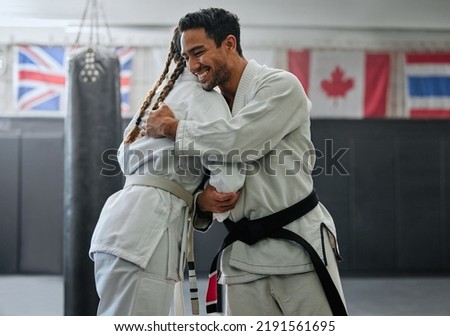 . Karate trainer giving hug to female student for motivation, coach embracing for support and celebration after winning competition. Teammates and friends training and learning martial arts at a gym Royalty-Free Stock Photo #2191561695