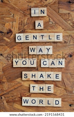 in a gentle way you can shake the world text on wooden square, motivation and inspiration quotes Royalty-Free Stock Photo #2191568431
