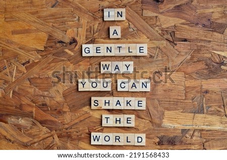 in a gentle way you can shake the world text on wooden square, motivation and inspiration quotes Royalty-Free Stock Photo #2191568433