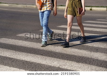 teenage schoolchildren, a boy and a girl cross the road at a pedestrian crossing Royalty-Free Stock Photo #2191580901