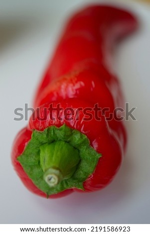 Close-up of fresh red pointed bell pepper against white background in macrophotography