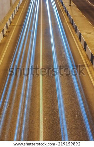 Night road in city with passing cars slow shutter speed.