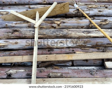 Stacked wood background in construction site with wooden trowel and broomstick