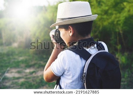 Young Child Taking Photos in the street.