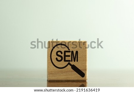 Search Engine Marketing(SEM) for business,marketing concept., SEM word and magnifying glass icon on wooden cube over white background.