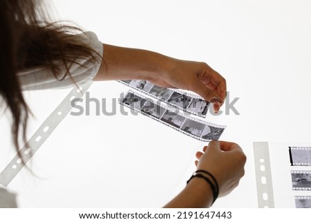 two women cut 35mm film negatives in a photography lab light table isolated on white closeup organised high quality analog hobby person cinema business laboratory work tidy chemistry studio photos HQ