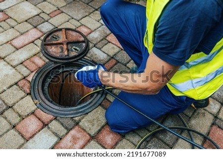 service worker cleaning blocked sewer line with hydro jetting Royalty-Free Stock Photo #2191677089