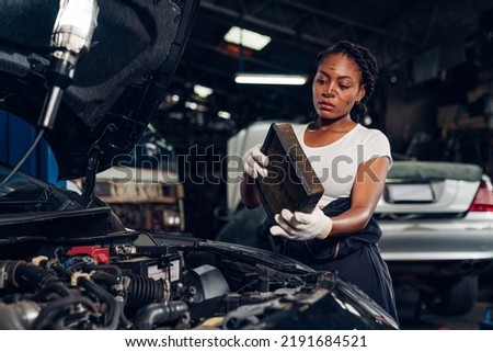 Woman auto mechanic checking air filter and repair maintenance auto engine is problems at car repair shop.
