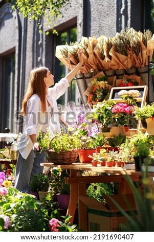 a woman chooses a bouquet of lavender at a flower market outside