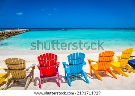 Idyllic beach with rustic wooden adirondack chairs in Aruba, Dutch Antilles Royalty-Free Stock Photo #2191711929