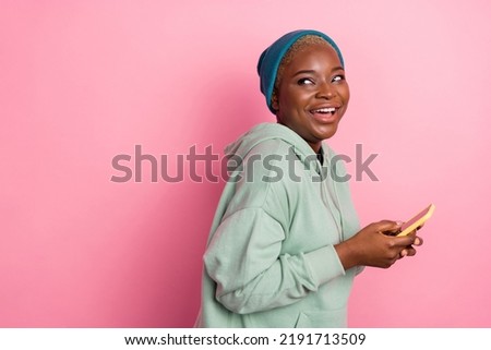 Profile side picture of cute laughing female surfing in social media see in empty space new phone ad isolated on pink color background