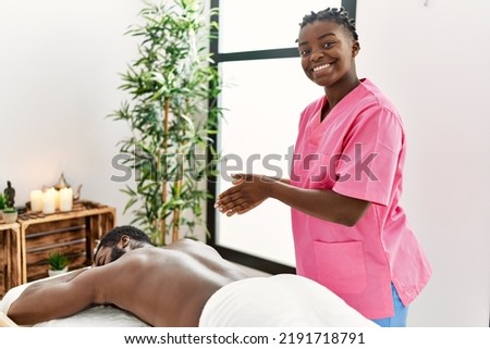 Young physiotherapist woman smiling happy prepared to do massage at the clinic. Royalty-Free Stock Photo #2191718791