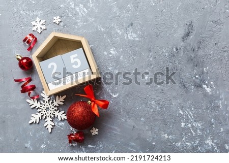 Christmas calendar 25 december. Christmas gift, fir branches, pine cones. Flat lay, top view. New Year decorations on a colored background.
