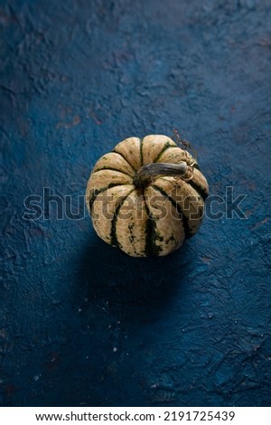 One pumpkin on blue surface Halloween background