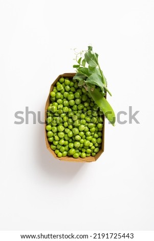 Overhead view of fresh sweet green peas seeds in paper container food