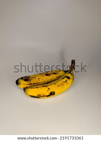 photo of banana with a white background, yellow banana with a spot of black spot