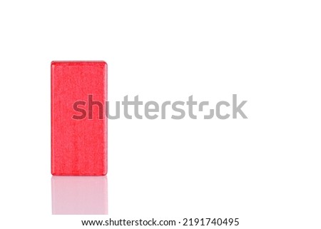 Wooden cube of red color on a white background close up