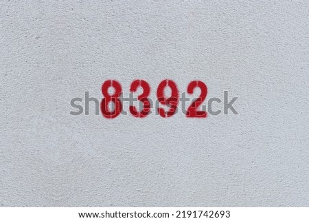 Red Number 8392 on the white wall. Spray paint.
