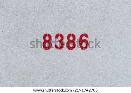 Red Number 8386 on the white wall. Spray paint.
