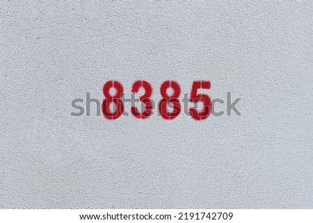 Red Number 8385 on the white wall. Spray paint.

