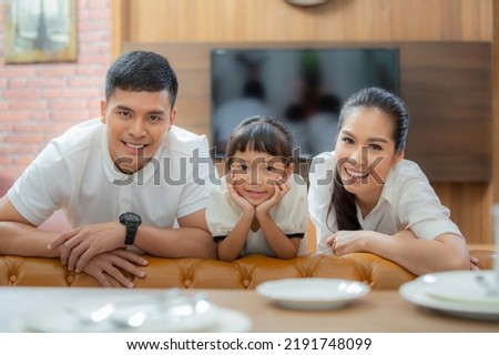 Asian family enjoy movie at living room togather with vintage sofa at home