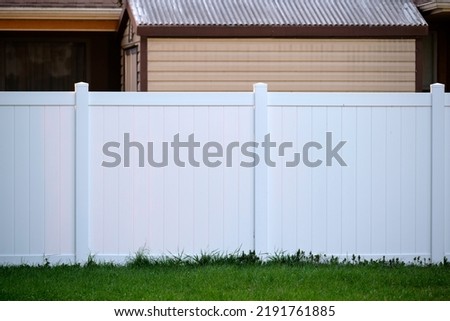 White plastic fence for back yard protection and privacy Royalty-Free Stock Photo #2191761885