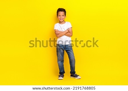 Full size photo of boss little boy crossed arms wear white t-shirt jeans sneakers isolated on yellow color background Royalty-Free Stock Photo #2191768805