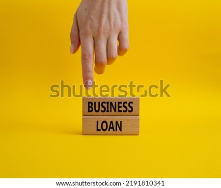 Business loan symbol. Concept words business loan on wooden blocks. Beautiful yellow background. Businessman hand. Business and business loan concept. Copy space.