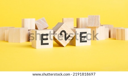 wooden blocks with text E2E on yellow background. exchange to exchange concept