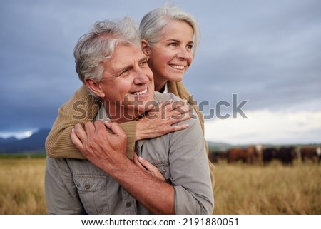 Mature couple embracing and looking happy while bonding outdoors at a farm, carefree and loving. Senior husband and wife having peaceful day in nature, enjoying retirement and relationship Royalty-Free Stock Photo #2191880051