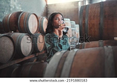 Winemaker womanwith white wine tasting glass, Chardonnay or quality alcoholic drink in winery, factory or warehouse. Entrepreneur in hospitality, winemaking industry testing flavor in cellar Royalty-Free Stock Photo #2191880183