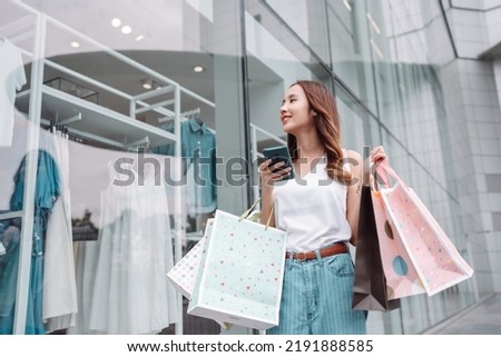 Beautiful asian female woman girl use smartphone and holding shopping bags, Walk enjoy smiling while doing shopping outside of department store malls window outdoors fashion lifestyle Royalty-Free Stock Photo #2191888585