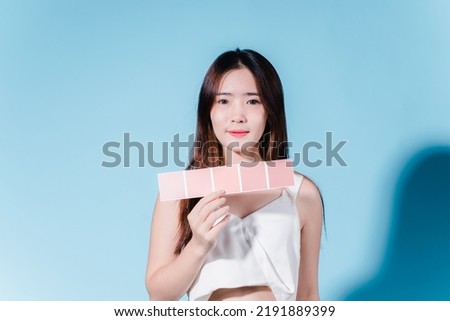 Charming asian beauty woman take color scale on the blue background