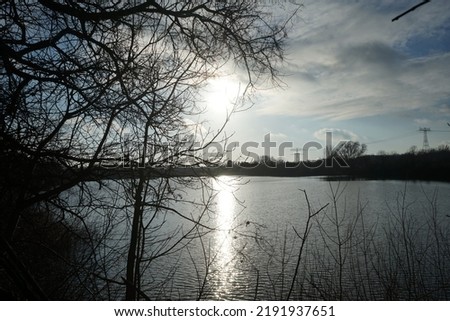 Low winter sun over Biesdorfer Baggersee lake in January. Berlin, Germany