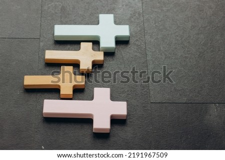 Wooden cross on a new black plastered brick wall. Concept of Religion. Many crosses