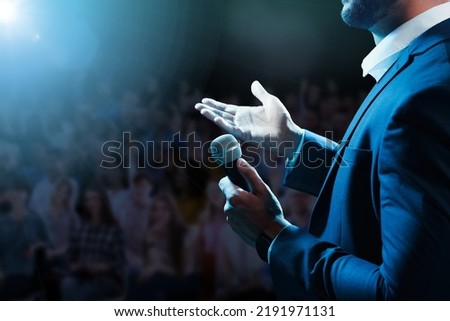 Motivational speaker with microphone performing on stage, closeup Royalty-Free Stock Photo #2191971131