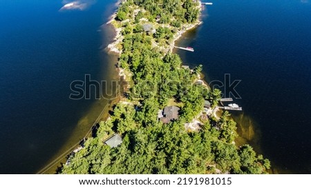 A photo from a drone showing an island from above. It shows lots of trees and water.