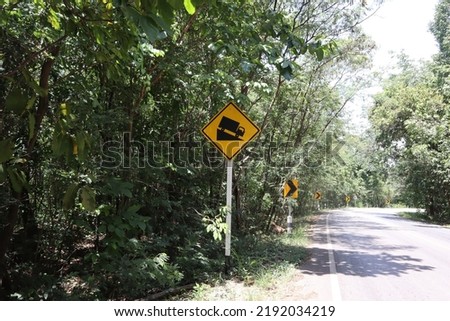 Traffic and travel warning signs located on the side of the road for motorists and road users. The meaning of this sign is Be careful of the steep slopes down the hill.

