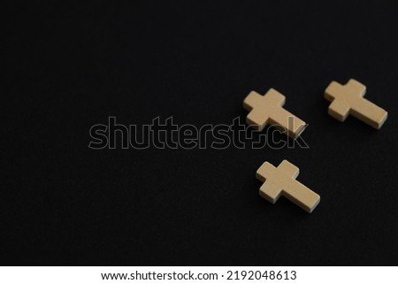 Christian cross on black background, top view with space for text. Religion concept