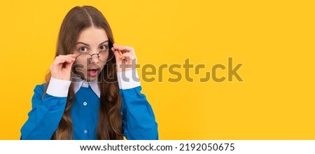Just curious. Curious girl in eyeglasses. Nerdy-looking kid yellow background. Back to school. Child face, horizontal poster, teenager girl isolated portrait, banner with copy space.
