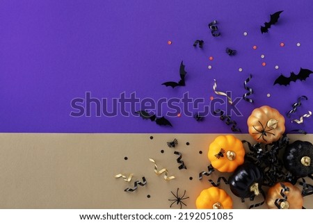 Halloween holiday card with party decorations of pumpkins, bats, spiders on gold violet background top view. Happy halloween greeting poster in flat lay style.