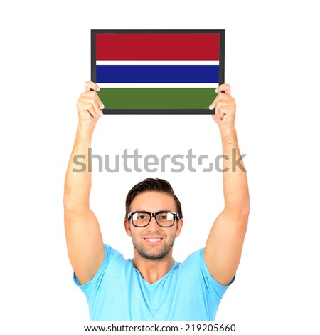 Portrait of a young casual man holding up board with National flag of Gambia