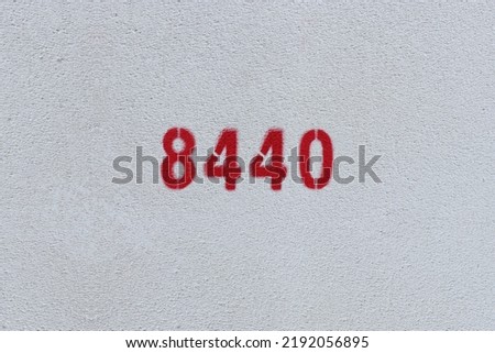 Red Number 8440 on the white wall. Spray paint.
