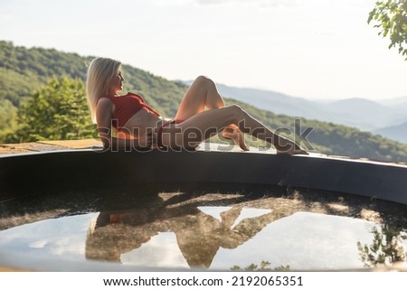 A woman wearing a bathing suit in an open air bath with mountain view She was relaxing in the open-air bath on vacation. tourism travel lifestyle photography.
