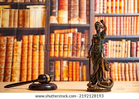 Lawyer office. Statue of Justice, scales and Judge's gavel against the backdrop of a wall of books or a library . Legal law, advice and justice concept