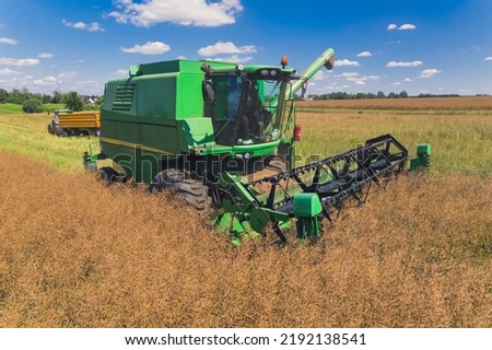 agricultural field during harvest time with industrial combine machine in the working process. High quality photo
